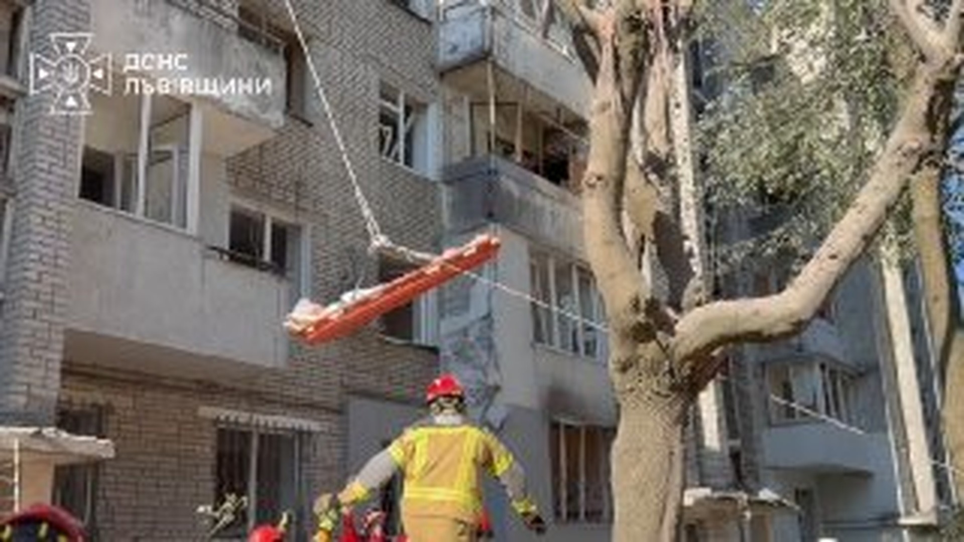Рятувальники ДСНС виносять мешканку з-під завалів зруйнованого ракетою багатоповерхового будинку у Львові під час пошуково-рятувальної операції