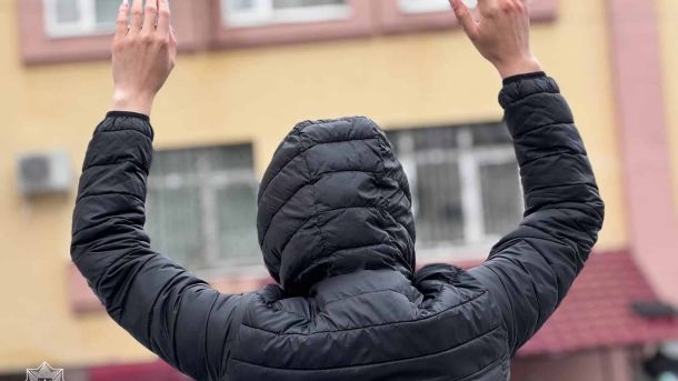 Затриманий з піднятими руками перед будівлею поліції, ілюстративне фото патрульної поліції