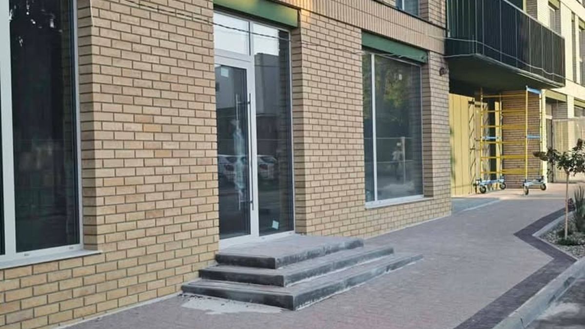 Вхід до новобудови на вулиці Базарній у Львові зі сходами та одним пандусом поруч із входами врівень із тротуаром