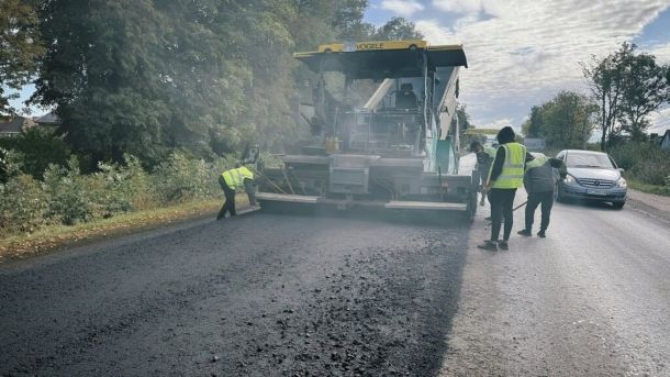 Асфальтоукладач і дорожники укладають нове покриття під час ремонту дороги, ілюстративне фото