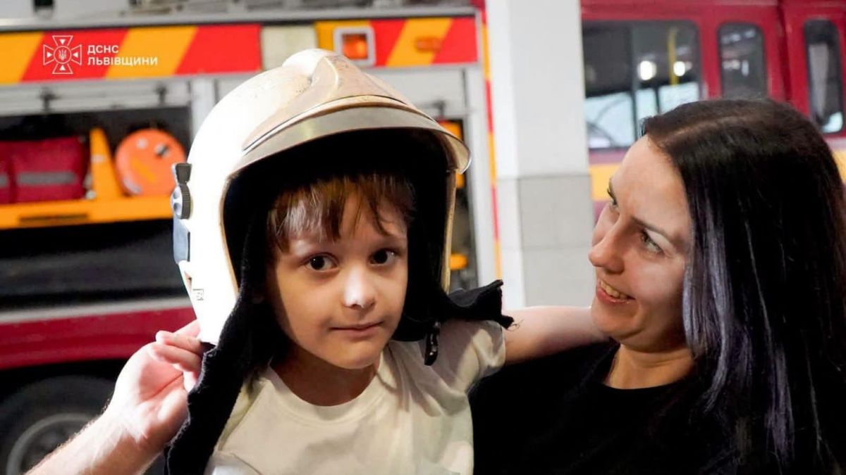 Шестирічний Сашко з родиною у пожежній частині Львова разом із рятувальниками, які врятували хлопчика з-під завалів на вулиці Патона