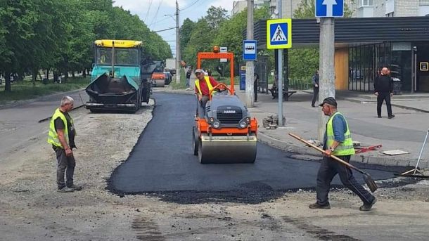 Дорожники асфальтують міську вулицю біля пішохідного переходу, ілюстративне фото