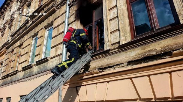 Рятувальники гасять пожежу в квартирі на вулиці Мечнікова у Львові, з вікна вибивається чорний дим