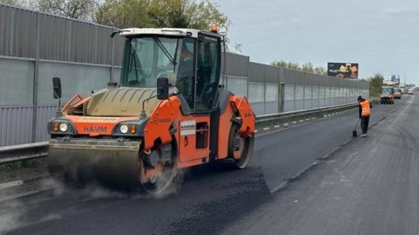 Дорожній коток ущільнює свіжий асфальт під час ремонту дороги, ілюстративне фото