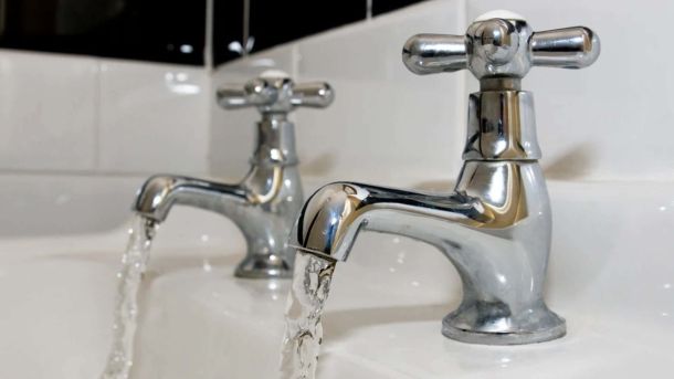 Вода тече з двох кранів умивальника — ілюстративне фото про водопостачання